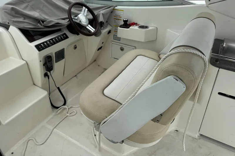 Slide: The Image of 2013 Sea Ray Sundancer 310 helm with beige seating and steering wheel. - 17