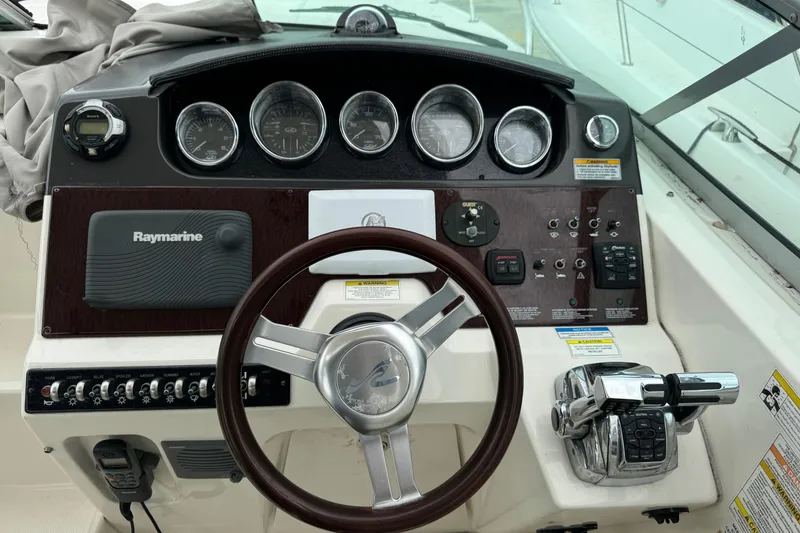 Slide: The Image of 2013 Sea Ray Sundancer 310 helm with Raymarine navigation system and classic wood steering wheel. - 18