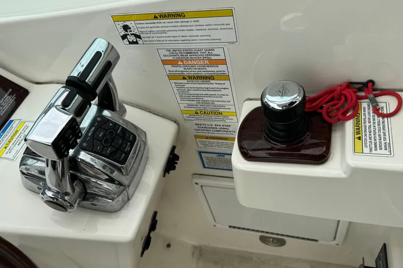 Slide: The Image of Control panel of a 2013 Sea Ray Sundancer 310 boat with warning labels. - 24