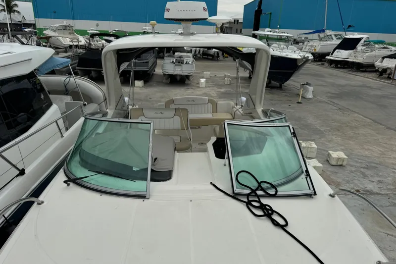 Slide: The Image of 2013 Sea Ray Sundancer 310 yacht docked in a marina, surrounded by other boats. - 28