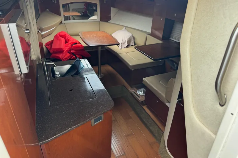 Slide: The Image of 2013 Sea Ray Sundancer 310 interior with kitchenette and seating area. - 31