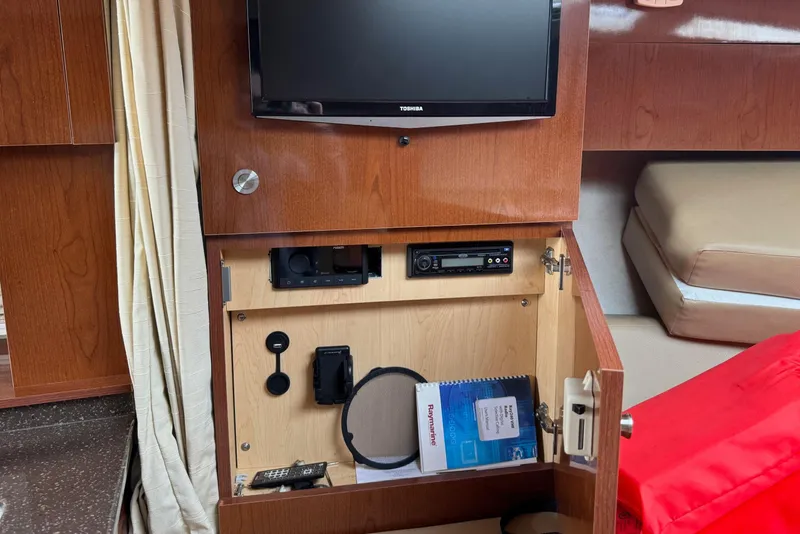 Slide: The Image of Interior of 2013 Sea Ray Sundancer 310 with TV, storage, and electronic equipment. - 37