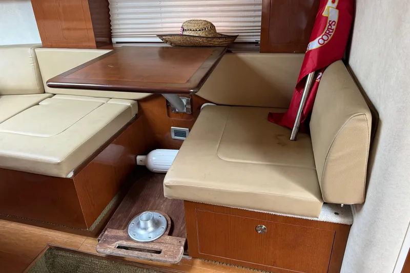 Slide: The Image of Interior of 2013 Sea Ray Sundancer 310 with beige seating and wooden table. - 38