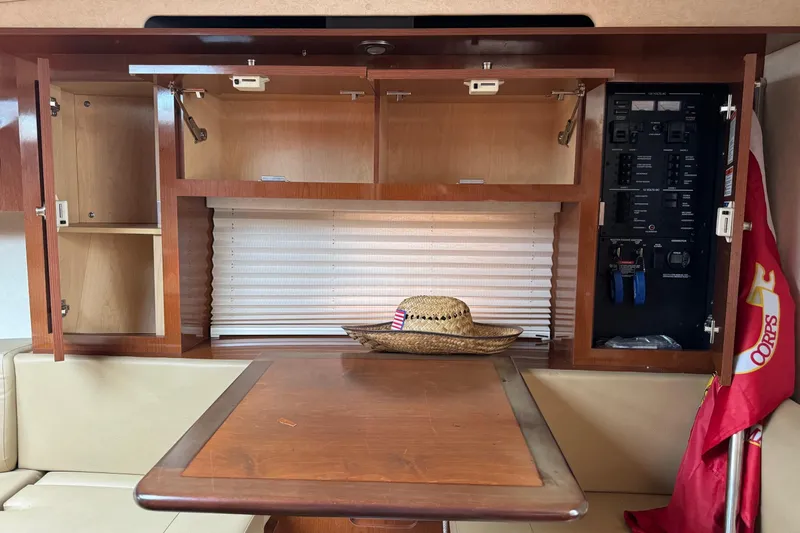 Slide: The Image of 2013 Sea Ray Sundancer 310 interior with open cabinets, control panel, and table. - 40