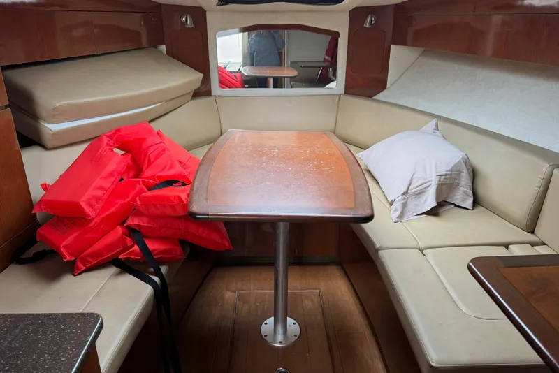 Slide: The Image of Interior of 2013 Sea Ray Sundancer 310 with seating, table, and life jackets. - 42