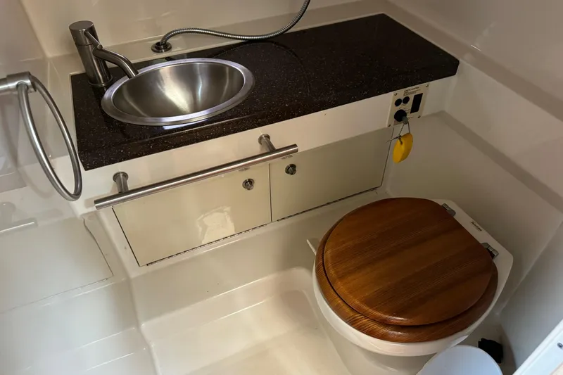 Slide: The Image of 2013 Sea Ray Sundancer 310 bathroom with sink and wooden toilet seat. - 43