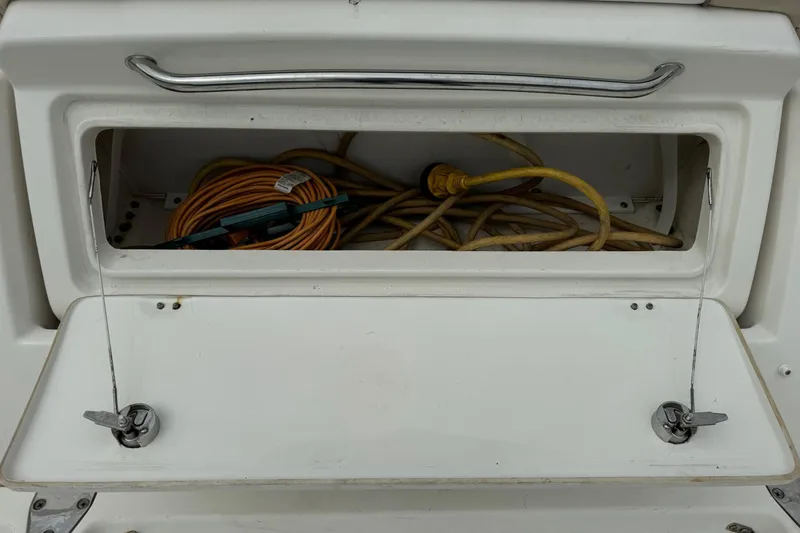 Slide: The Image of Storage compartment on a 2013 Sea Ray Sundancer 310 boat with coiled cables. - 5