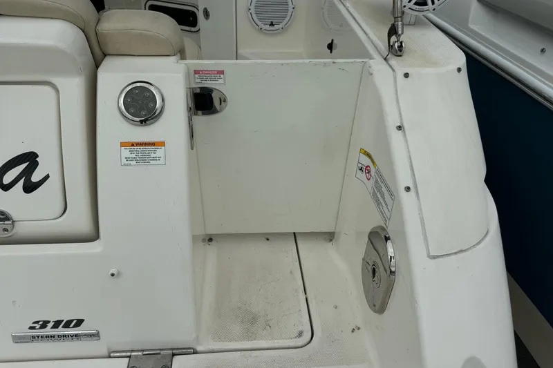 Slide: The Image of 2013 Sea Ray Sundancer 310 boat stern area with warning labels and seating. - 7