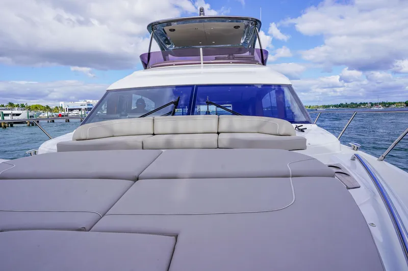 Slide: The Image of 2022 Princess F62 yacht with spacious deck and luxurious seating, docked by the water. - 15