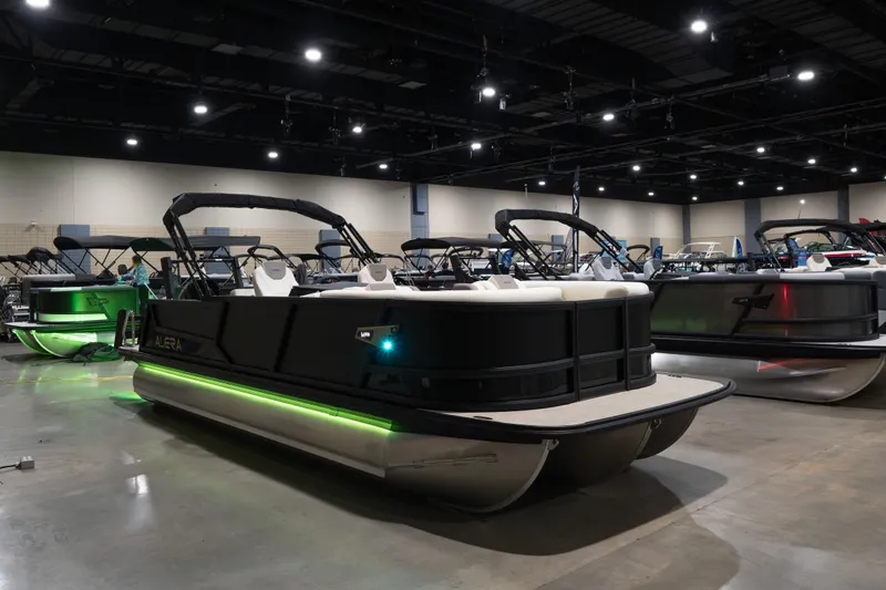 Slide: The Image of 2026 Alera M23Q pontoon boat with green LED lights displayed indoors. - 5