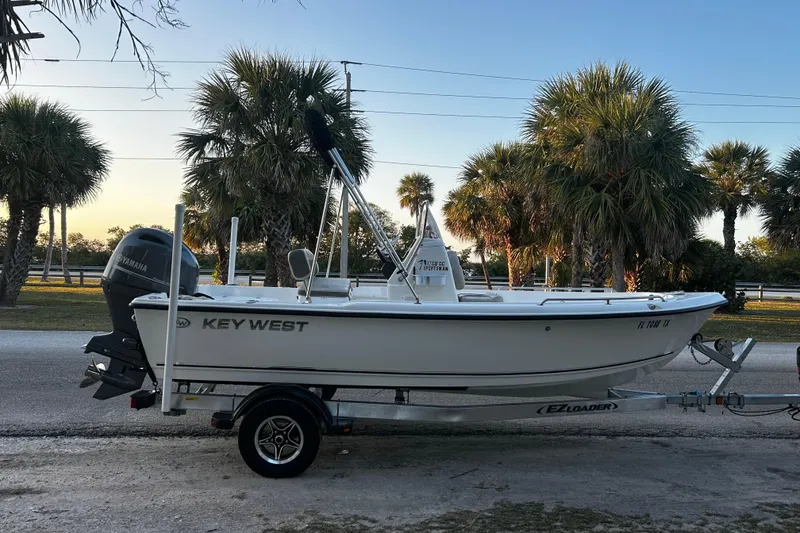 The Image of 2025 Key West 1720 Center Console boat on trailer, palm trees in background. - 1