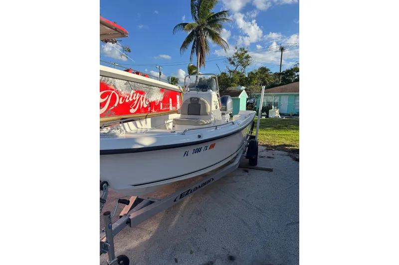 Slide: The Image of 2025 Key West 1720 Center Console boat on trailer, sunny day, palm tree background. - 10