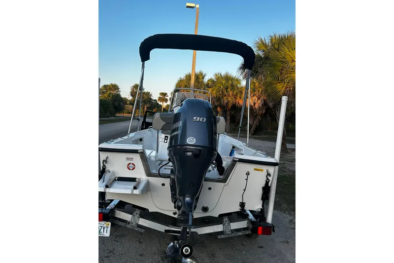 Slide: The Image of 2025 Key West 1720 Center Console boat with Yamaha engine, parked near palm trees. - 13