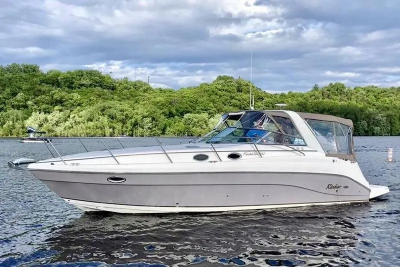 The Image of 2005 Rinker Fiesta Vee 342 boat on a scenic lake with lush green trees. - 0