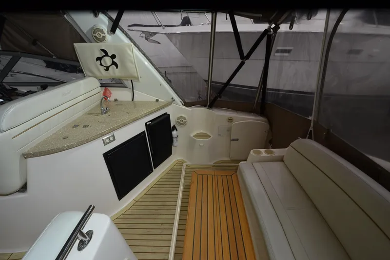 Slide: The Image of 2005 Rinker Fiesta Vee 342 interior with seating, kitchenette, and wood flooring. - 17