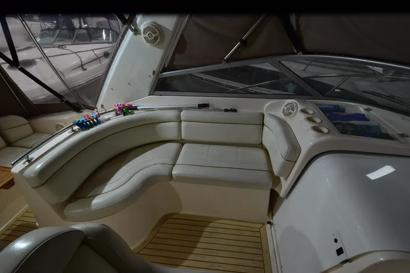 Slide: The Image of 2005 Rinker Fiesta Vee 342 boat interior with curved seating and wooden flooring. - 24