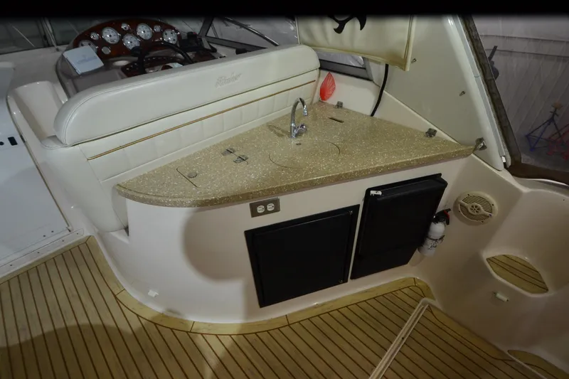 Slide: The Image of 2005 Rinker Fiesta Vee 342 boat interior with kitchenette and seating area. - 25