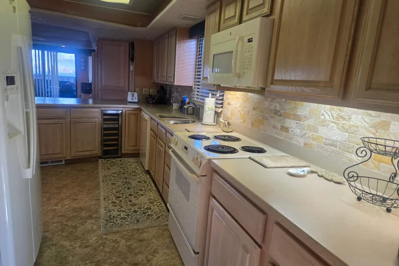 Slide: The Image of Kitchen interior of 1996 Sumerset 82'x18' Widebody houseboat with modern appliances. - 17
