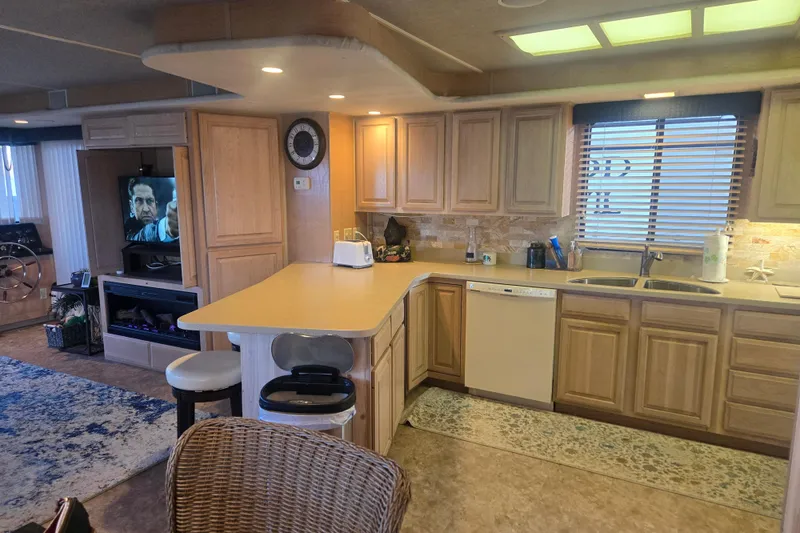 Slide: The Image of Interior of a 1996 Sumerset 82'x18' Widebody houseboat kitchen with wooden cabinets and modern appliances. - 19