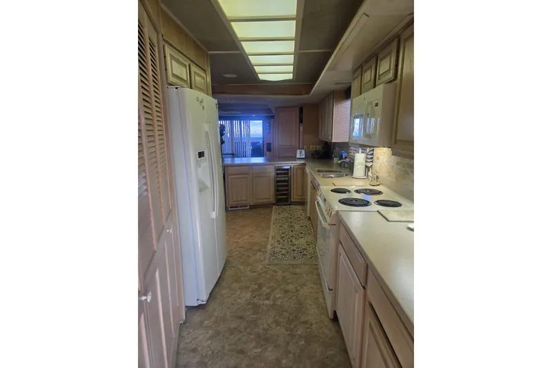 Slide: The Image of Kitchen interior of 1996 Sumerset 82'x18' Widebody houseboat with modern appliances. - 21