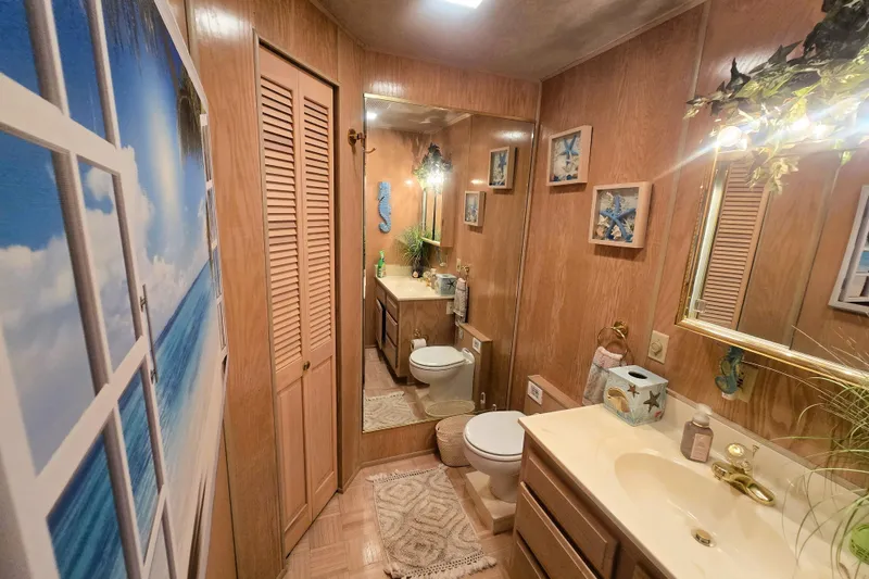 Slide: The Image of Bathroom in 1996 Sumerset 82'x18' Widebody houseboat with wood paneling and beach-themed decor. - 23