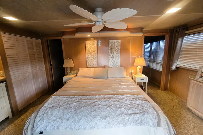 Slide: The Image of Cozy bedroom in a 1996 Sumerset 82'x18' Widebody houseboat with elegant decor and ceiling fan. - 30