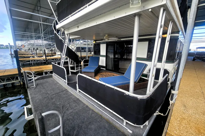 Slide: The Image of 1996 Sumerset 82'x18' Widebody houseboat with outdoor seating and spiral staircase in marina. - 38
