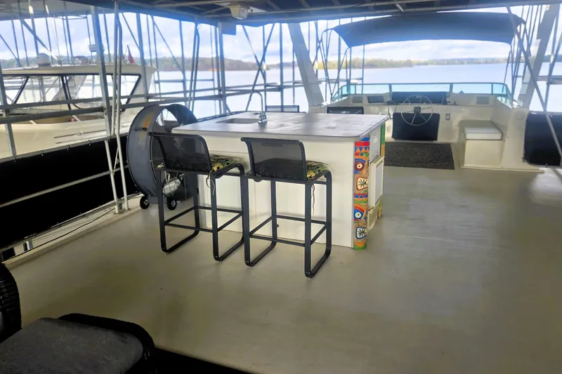 Slide: The Image of 1996 Sumerset 82'x18' Widebody houseboat interior with bar stools and steering area. - 47
