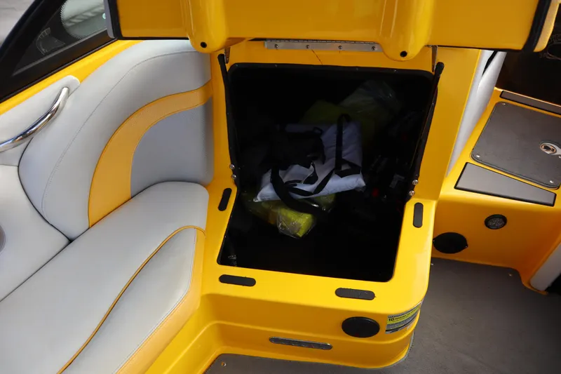 Slide: The Image of Yellow and white interior of 2014 Centurion Enzo SS210 boat with open storage compartment. - 12