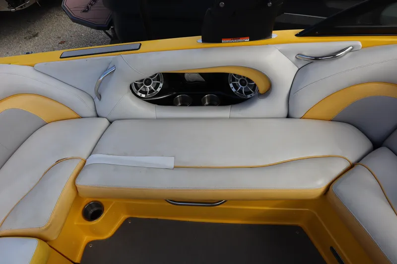 Slide: The Image of 2014 Centurion Enzo SS210 boat interior with yellow and white seating, cup holders, and speakers. - 17