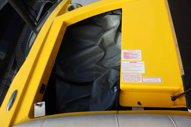 Slide: The Image of Yellow 2014 Centurion Enzo SS210 boat interior storage compartment with caution labels. - 26
