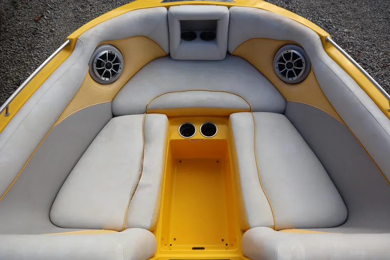 Slide: The Image of 2014 Centurion Enzo SS210 boat interior with yellow and gray seating, cup holders, and speakers. - 4