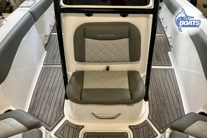 Slide: The Image of 2024 NauticStar 222 Offshore boat interior with cushioned seating and wood-style flooring. - 5