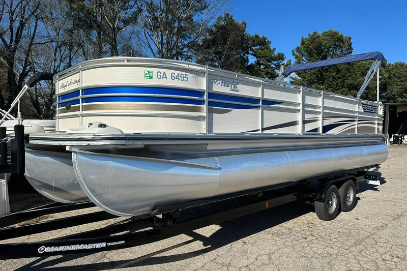 The Image of 2007 Harris Royal Heritage 260 O/B pontoon boat on trailer, parked outdoors. - 0