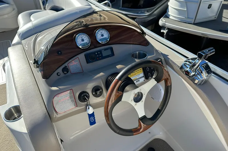 Slide: The Image of Steering console of a 2007 Harris Royal Heritage 260 O/B boat with gauges and controls. - 2