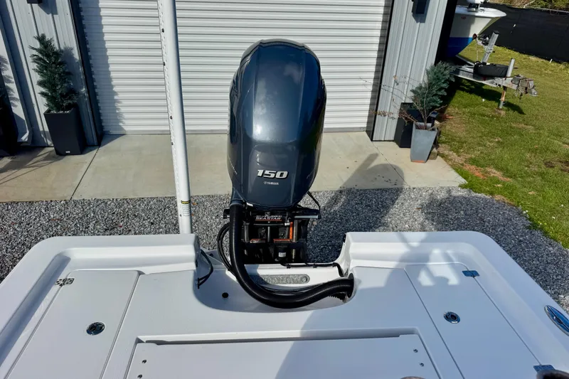 Slide: The Image of 2020 Sportsman Masters 207 Bay Boat with Yamaha 150 engine, parked near garage. - 11