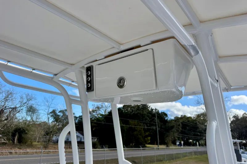 Slide: The Image of 2020 Sportsman Masters 207 Bay Boat T-top storage compartment, white finish, outdoor setting. - 15