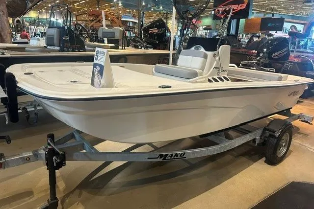The Image of 2026 Mako Pro Skiff 13 CC boat displayed on a trailer in a showroom. - 0