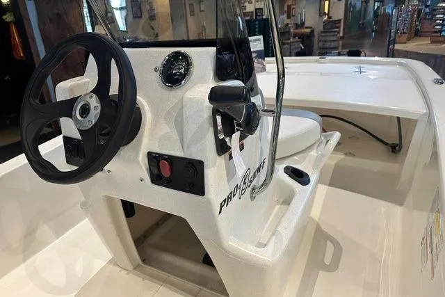 Slide: The Image of 2026 Mako Pro Skiff 13 CC boat interior with steering console and controls. - 7