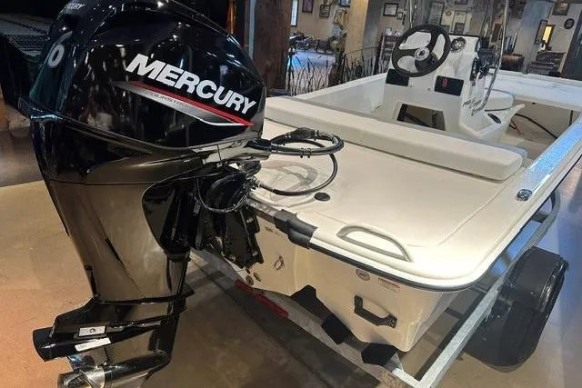 Slide: The Image of 2026 Mako Pro Skiff 13 CC with Mercury outboard motor in showroom. - 5