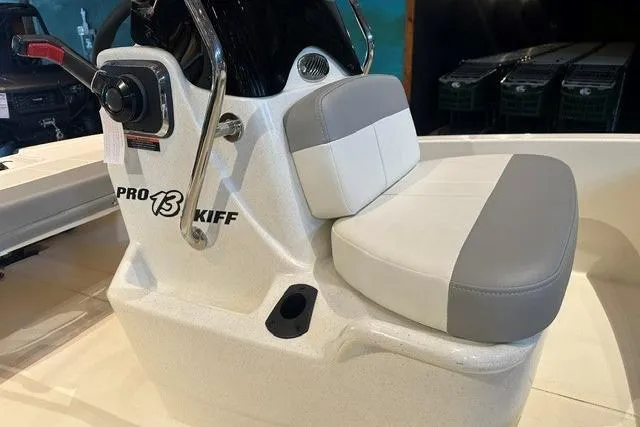 Slide: The Image of 2026 Mako Pro Skiff 13 CC boat interior with steering console and cushioned seat. - 8