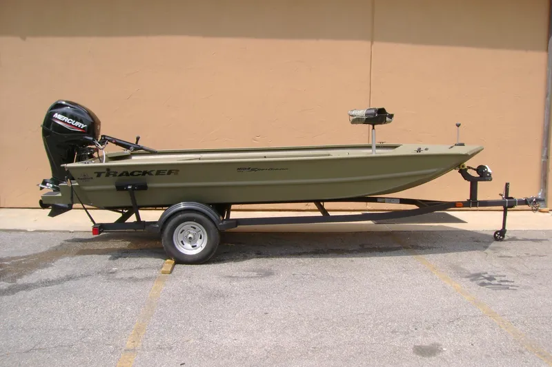 The Image of 2026 Tracker Grizzly 1654 T Sportsman boat on trailer, featuring Mercury outboard motor. - 0