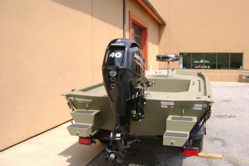 Slide: The Image of 2026 Tracker Grizzly 1654 T Sportsman boat with Mercury 40 engine, parked outdoors. - 4