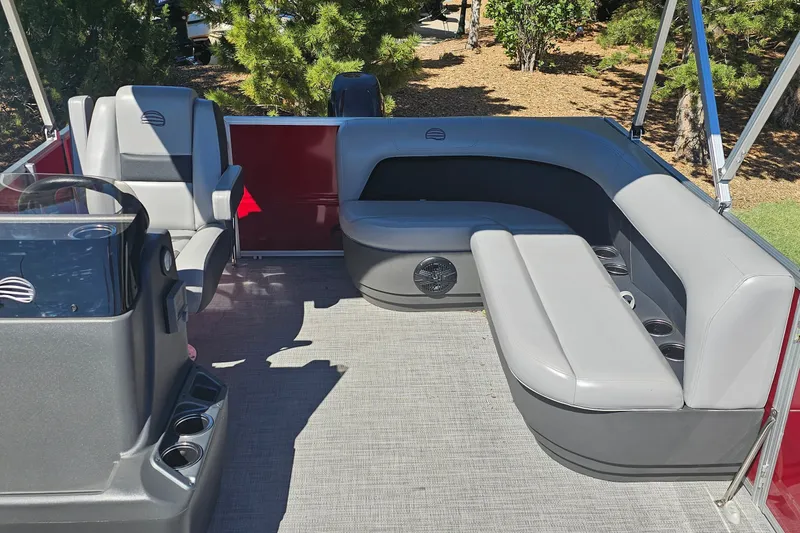 Slide: The Image of 2026 Sun Tracker Party Barge 16 DLX interior with gray seating and steering console. - 12