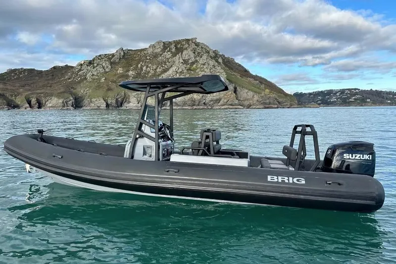 Slide: The Image of Manufacturer Provided Image: 2026 Brig Navigator 24 boat with Suzuki engine on scenic water backdrop. - 2