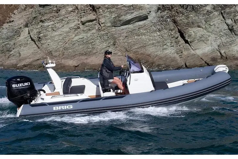 Slide: The Image of Manufacturer Provided Image: 2026 Brig Eagle 6.7 boat cruising near rocky shoreline with Suzuki engine. - 1