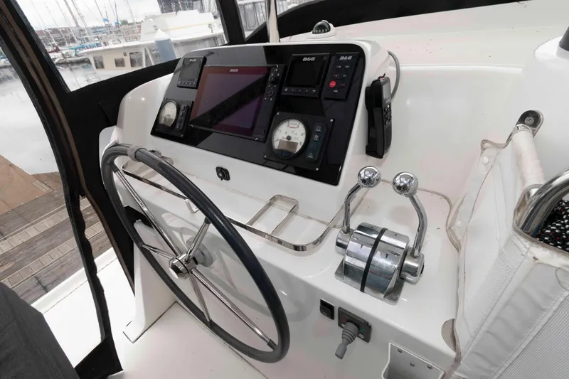 Slide: The Image of Cockpit of 2019 Lagoon 42 catamaran with steering wheel and navigation controls. - 12