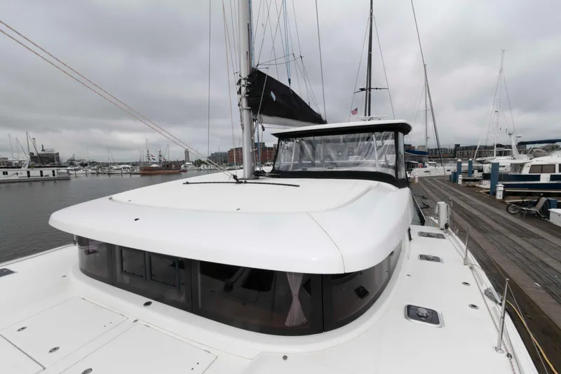 Slide: The Image of 2019 Lagoon 42 catamaran docked at a marina under cloudy skies. - 15