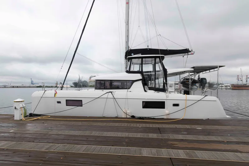 Slide: The Image of 2019 Lagoon 42 catamaran docked at a marina on a cloudy day. - 5