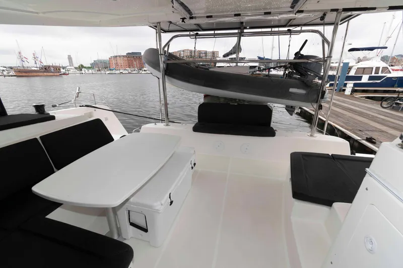 Slide: The Image of 2019 Lagoon 42 catamaran cockpit with seating, table, and docked at marina. - 7